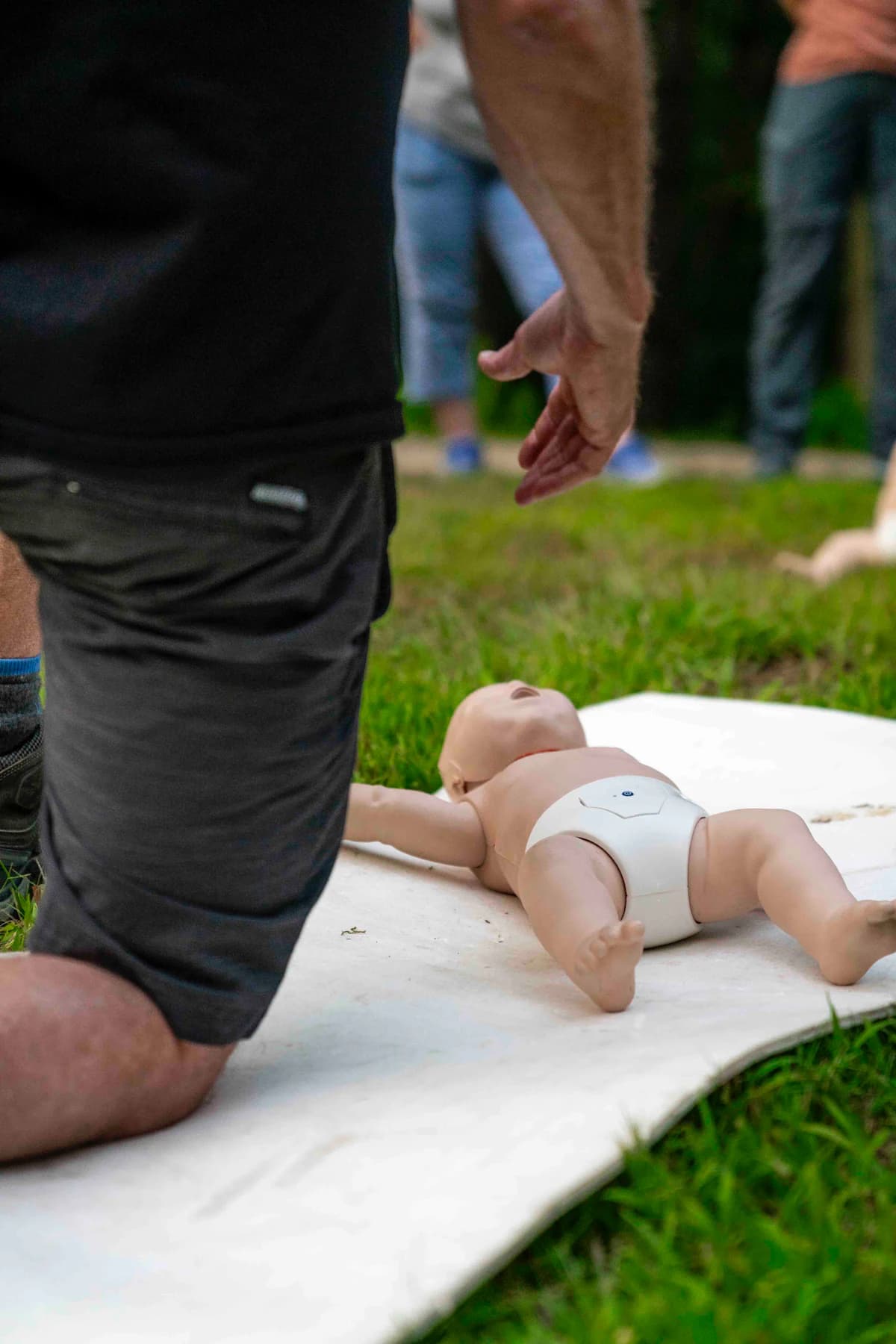 Person practicing infant CPR technique on a pediatric training mannequin